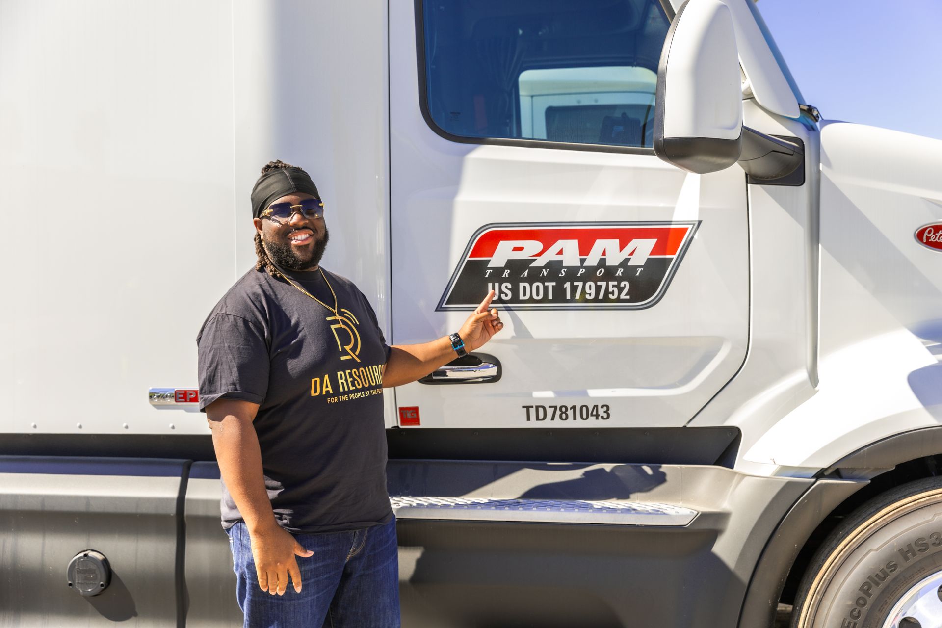 Mr. Drummer pointing to a PAM Transport truck